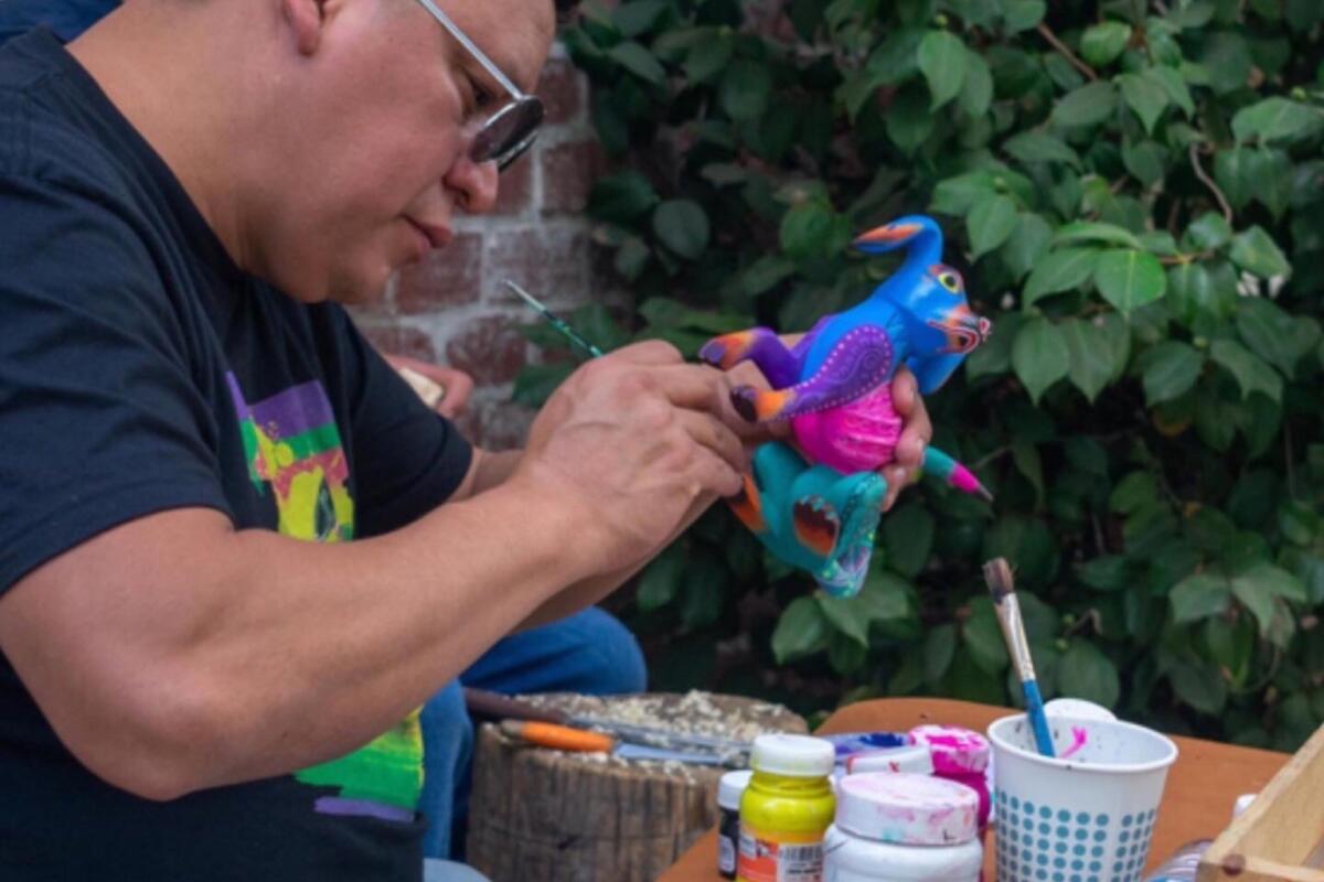 A person paints a figurine at a table.