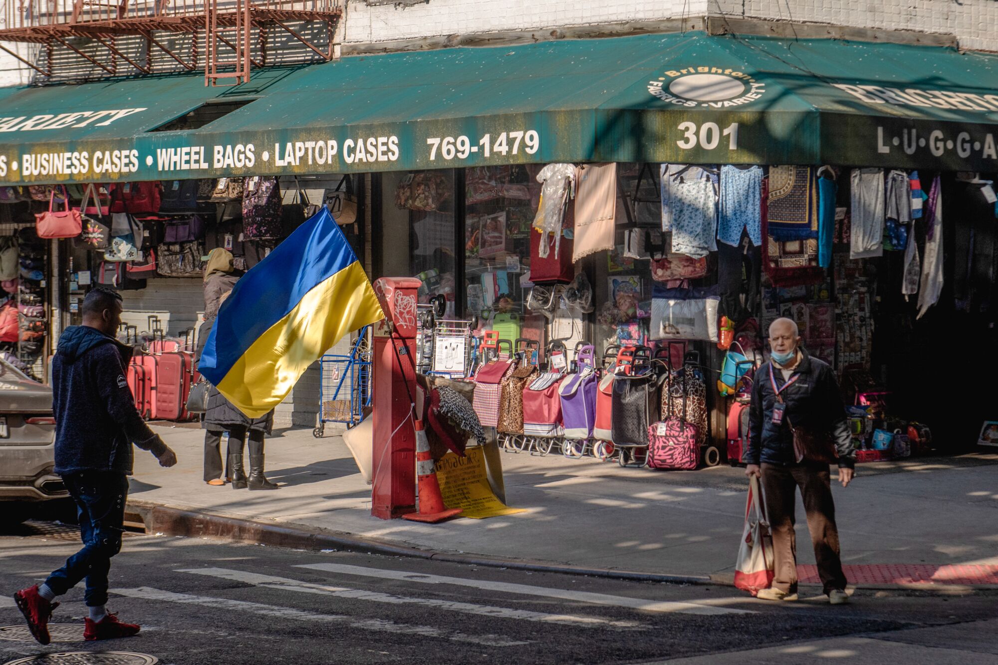 On a Brooklyn street corner, a large Ukrainian flag is displayed.