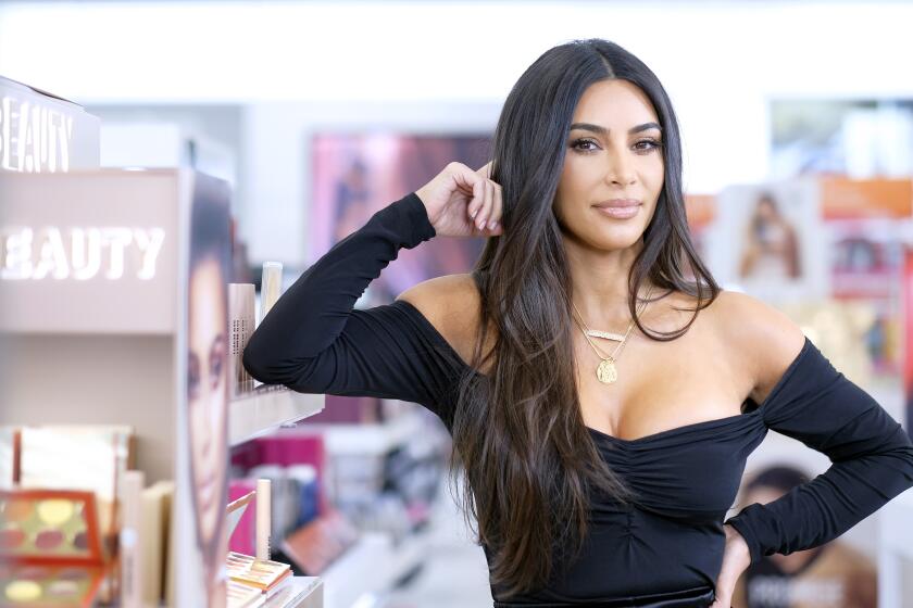 Kim Kardashian in a black dress at a beauty launch