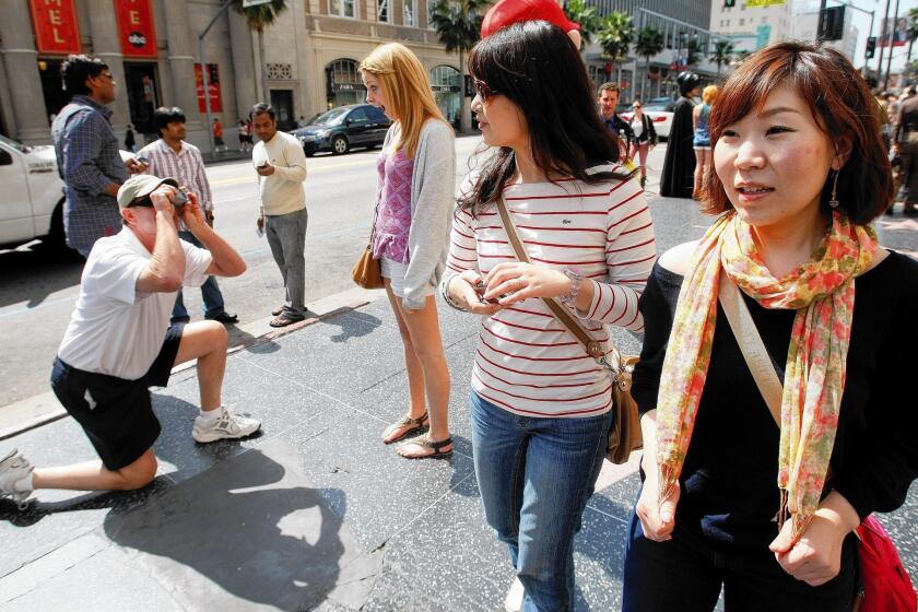 Visitors to L.A. County booked 26.6 million room nights in 2012, spent about $16.5 billion and supported 324,000 jobs in the region, according to a local tourism organization. Above, tourists Yuka Watanabe, right, and friend Miwako Tsugawa in Hollywood in 2011.