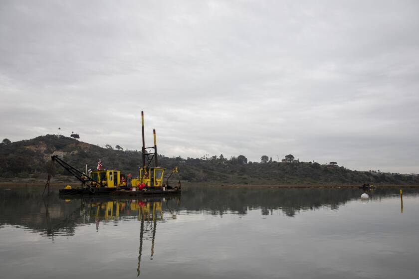 Encinitas, California - December 23: Dredge operators dig up sand from the San Elijo Lagoon that will be added to Cardiff State Beach on Thursday, Dec. 23, 2021 in Encinitas, California. About 63,000 cubic yards of sand will be sent to the beach by a conveyance pipeline. (Ana Ramirez / The San Diego Union-Tribune)