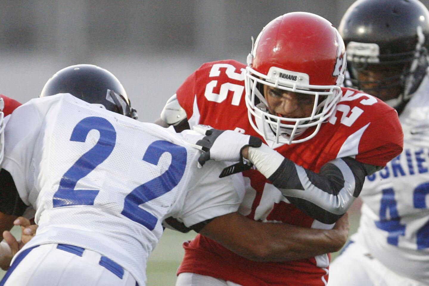 North Hollywood's Christian Campos, left, tackles Israel Montes during a game at John Burroughs High School in Burbank on Friday, September 7, 2012.