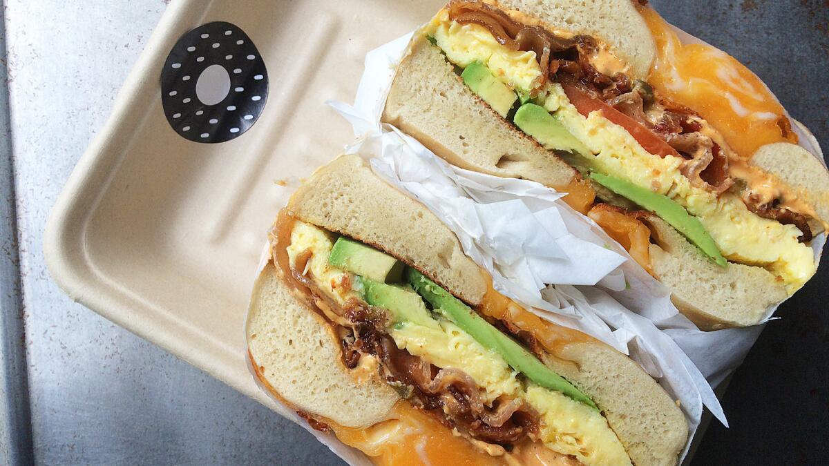 The "Game Over" bagel from Yeastie Boys bagel truck comes with a soft scrambled egg, bacon, tomato, beer cheese and jalapeno spread. This is just one of the food trucks participating in National Eat At a Food Truck Day today.