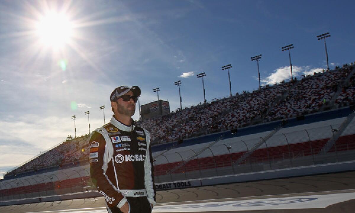 Defending NASCAR Sprint Cup champion Jimmie Johnson stands on the grid during qualifying for Sunday's race at Las Vegas Motor Speedway. Johnson is hoping to post his fifth-career win at Las Vegas this weekend.