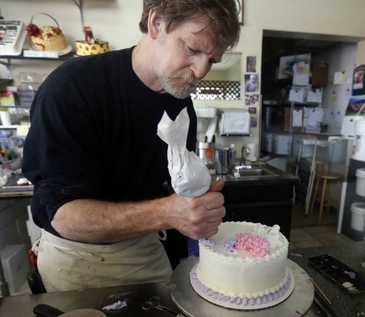 Masterpiece Cakeshop owner Jack Phillips decorates a cake inside his store in Lakewood, Colo.