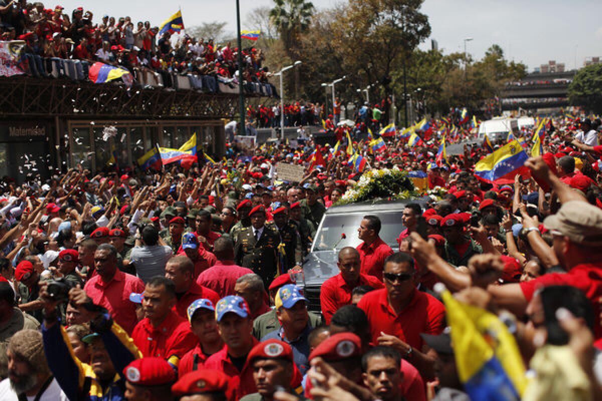 Supporters of Venezuela's late President Hugo Chavez crowd the street to watch his coffin pass by.
