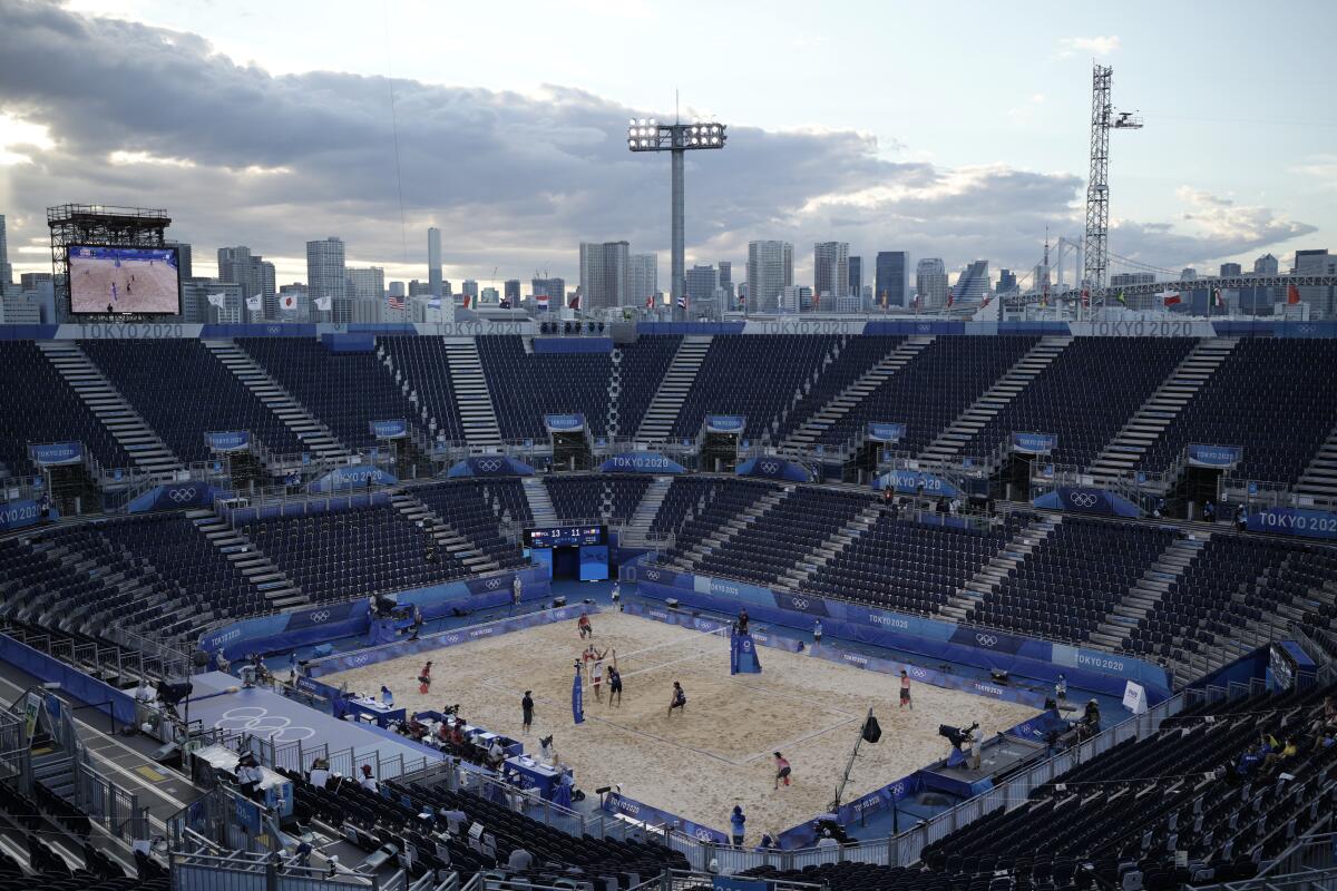 A nearly empty stadium surrounds a beach volleyball match at Shiokaze Park in Tokyo.