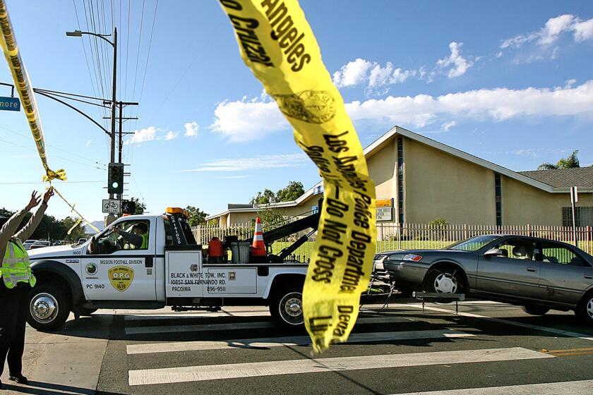 A car is towed away after a woman was shot and killed last August in Pacoima.