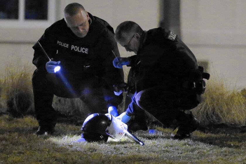 Police investigators gather evidence after two officers were shot after a night of protest in Ferguson.