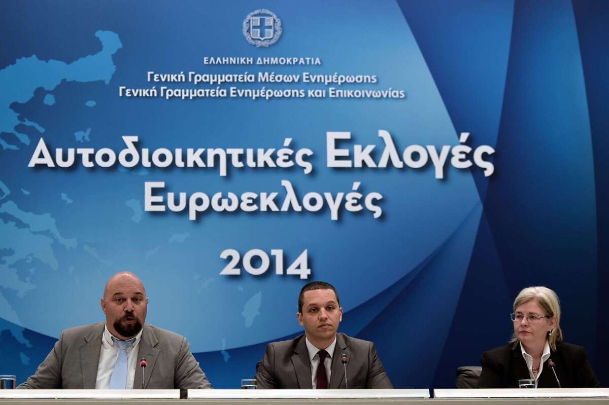 Golden Dawn lawmakers Ilias Panagiotaros, left, and Ilias Kasidiaris, center, at a televised news conference in Athens ahead of the May 25 EU elections; also attending was Eleni Zaroulia, wife of jailed leader Nikolaos Michaloliakos.
