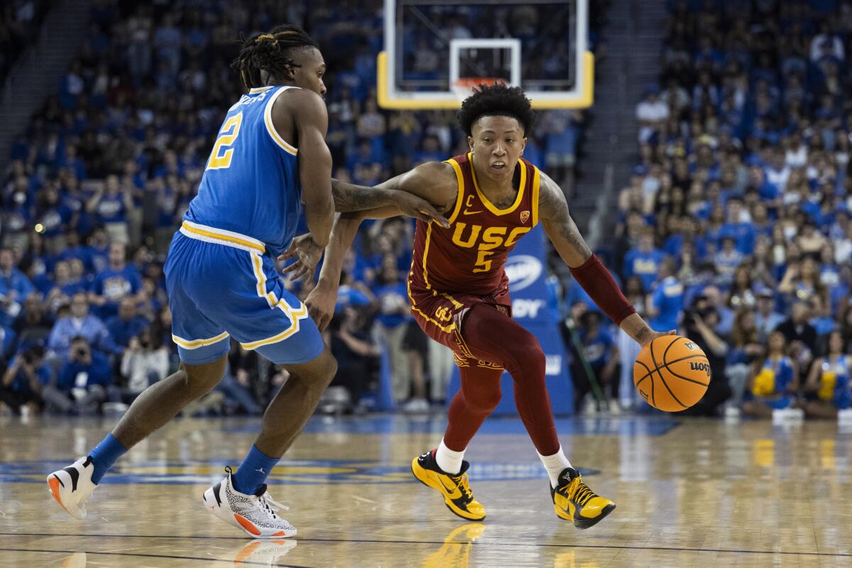 USC guard Boogie Ellis, right, drives past UCLA guard Dylan Andrews at Pauley Pavilion.