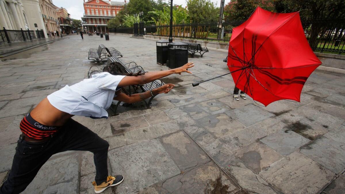 A man in the French Quarter plays with his umbrella in the wind of the storm Barry in New Orleans, on Friday.