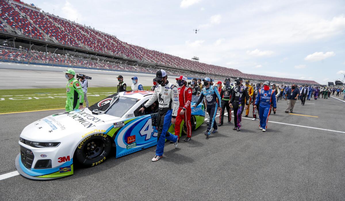 Fellow NASCAR drivers push the car of Bubba Wallace