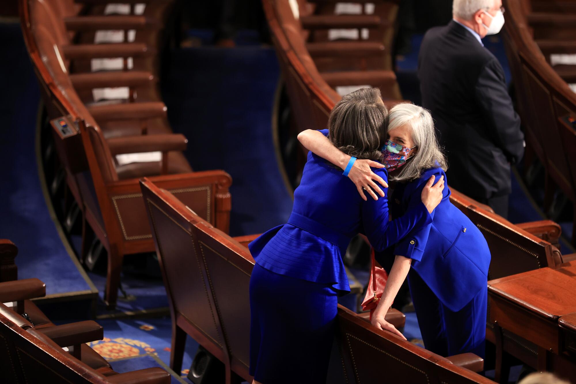 Two women hug.