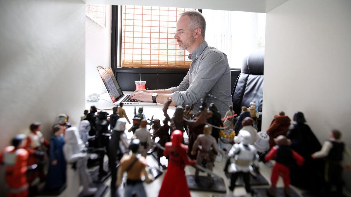 Writer John Gary works beside a collection of Star Wars figurines.