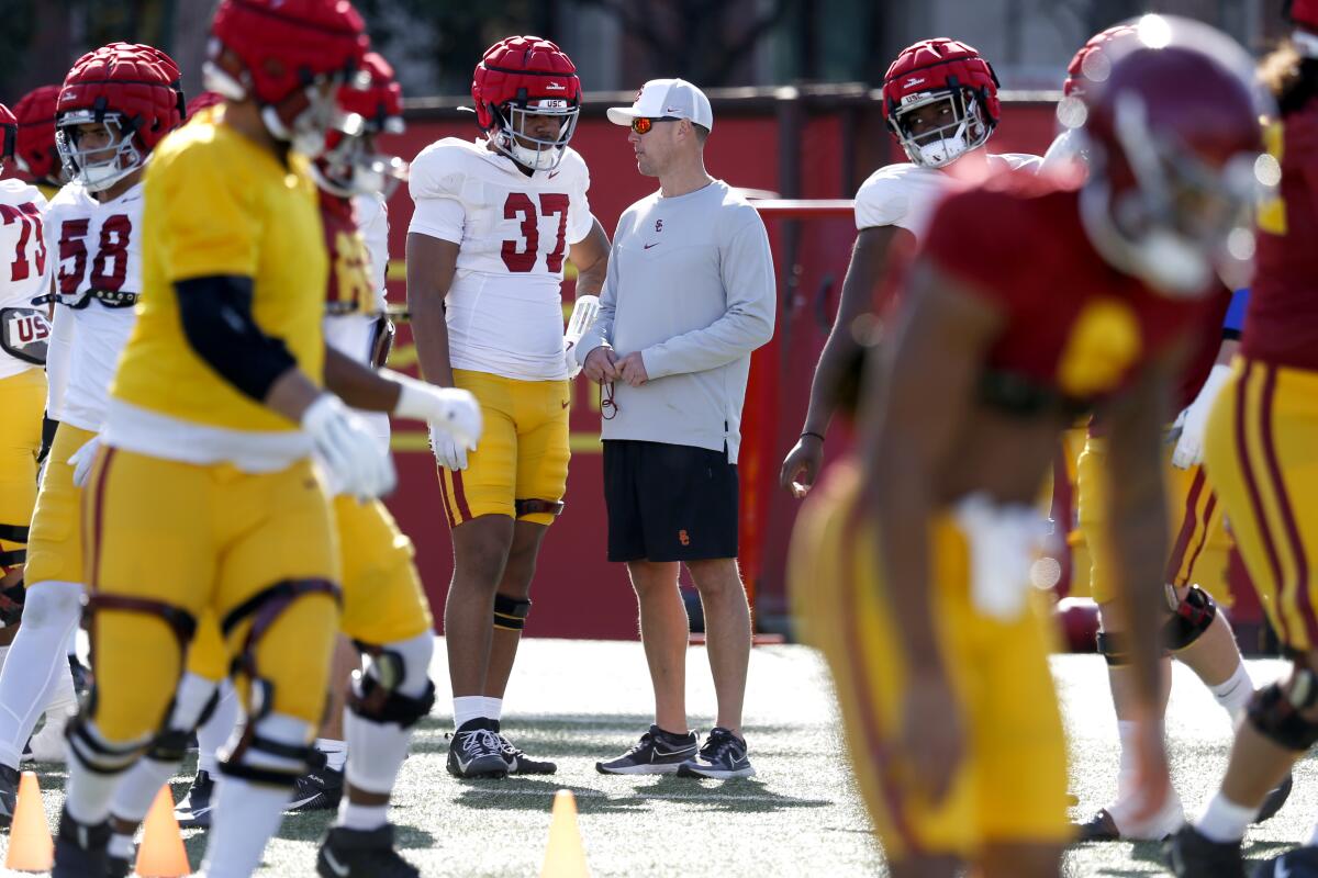 USC coach Lincoln Riley with defensive lineman Devan Thompkins at spring football practice.