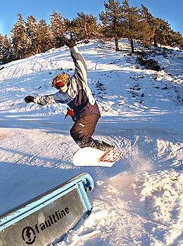 A snowboarder pops up on a rail at Mountain High ski resort in Wrightwood.