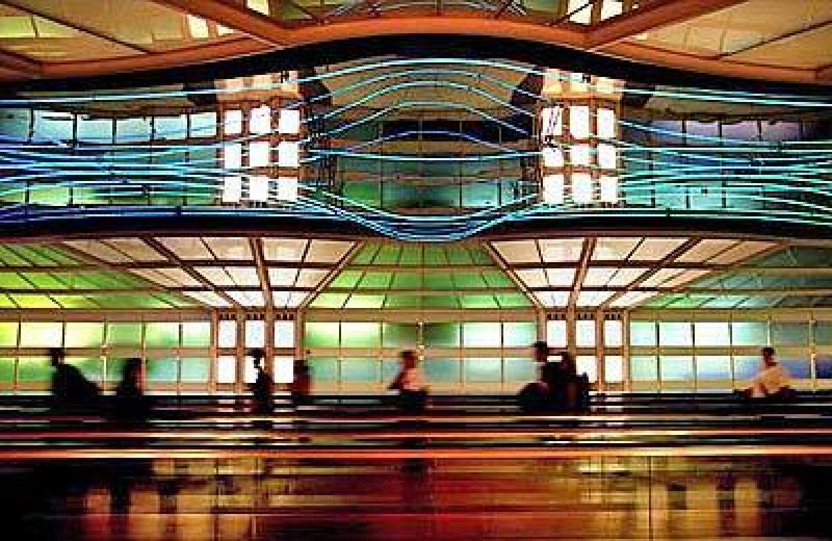 Passengers move between terminals through an underground tunnel at Chicago's O'Hare International Airport. The photo was shot with a 24mm lens on a digital Nikon D70.