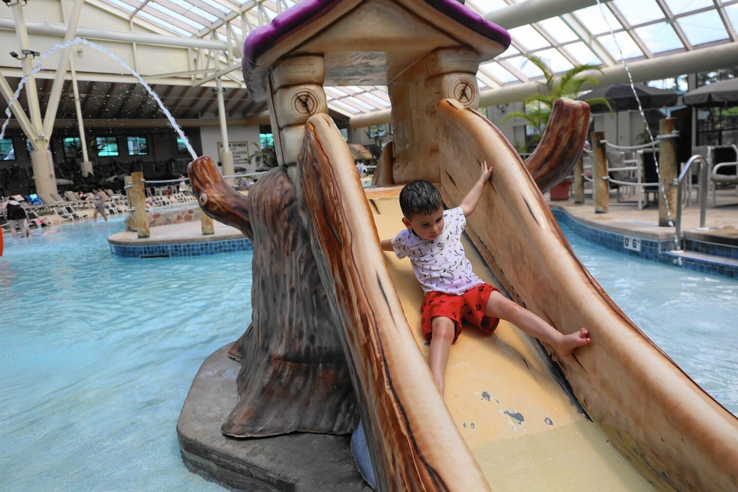 Aaron Brletic, 2, of Appleton, Wis., cautiously goes down a slide in the Wild WaterDome at Wilderness Resort.