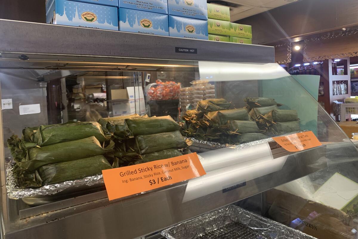 Banana-leaf-wrapped sticky rice packets stacked in a food warmer.