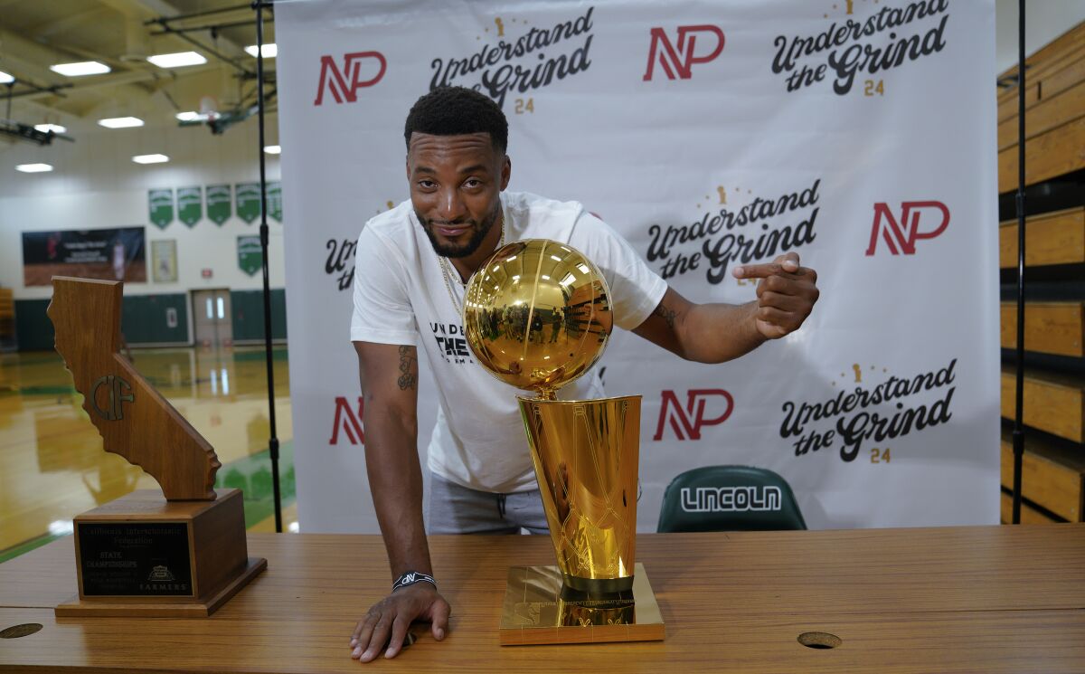 Toronto Raptors and San Diego native Norman Powell before hosting a meet and greet at his alma mater Lincoln High School on Thursday hams it up with the Larry O'Brien Trophy signifying an NBA championship.