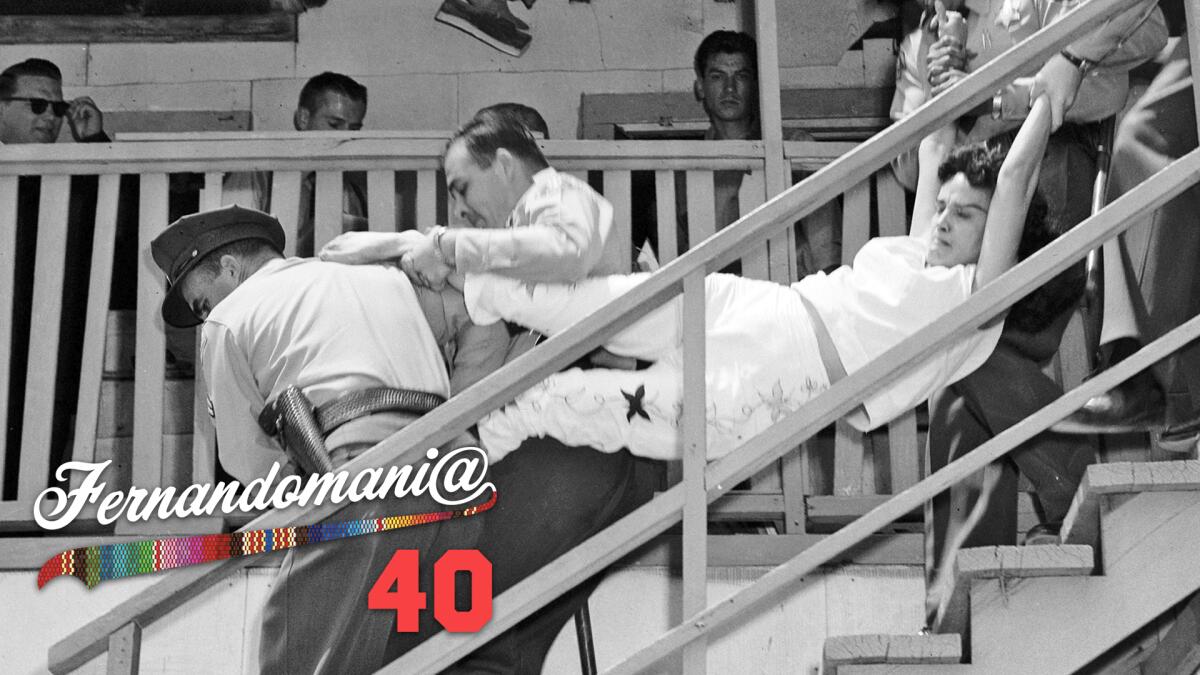 A photo of a woman being carried down a flight of stairs while being evicted, with a "Fernandomania @ 40" logo overlaid