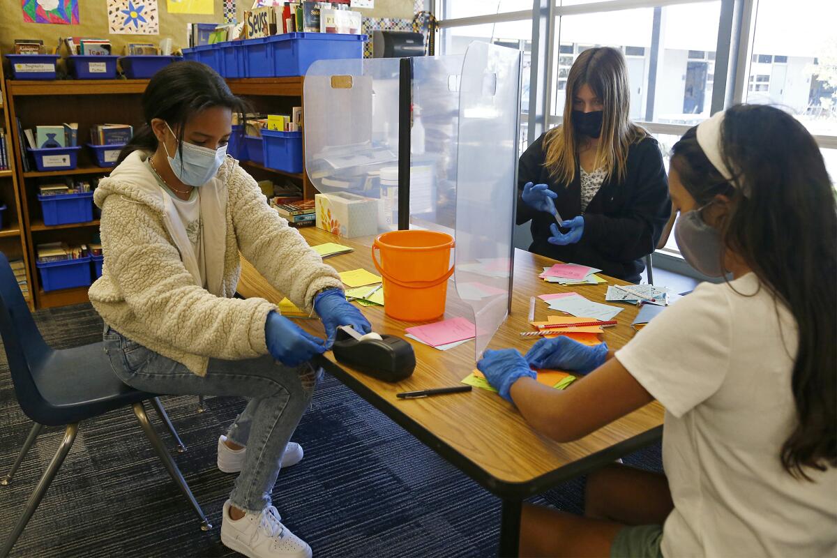 Sixth-graders Dior Harvey, 11, left, Marley Smith, 12, top right, and Lilah Parra, 11, bottom right, at Davis Magnet School.