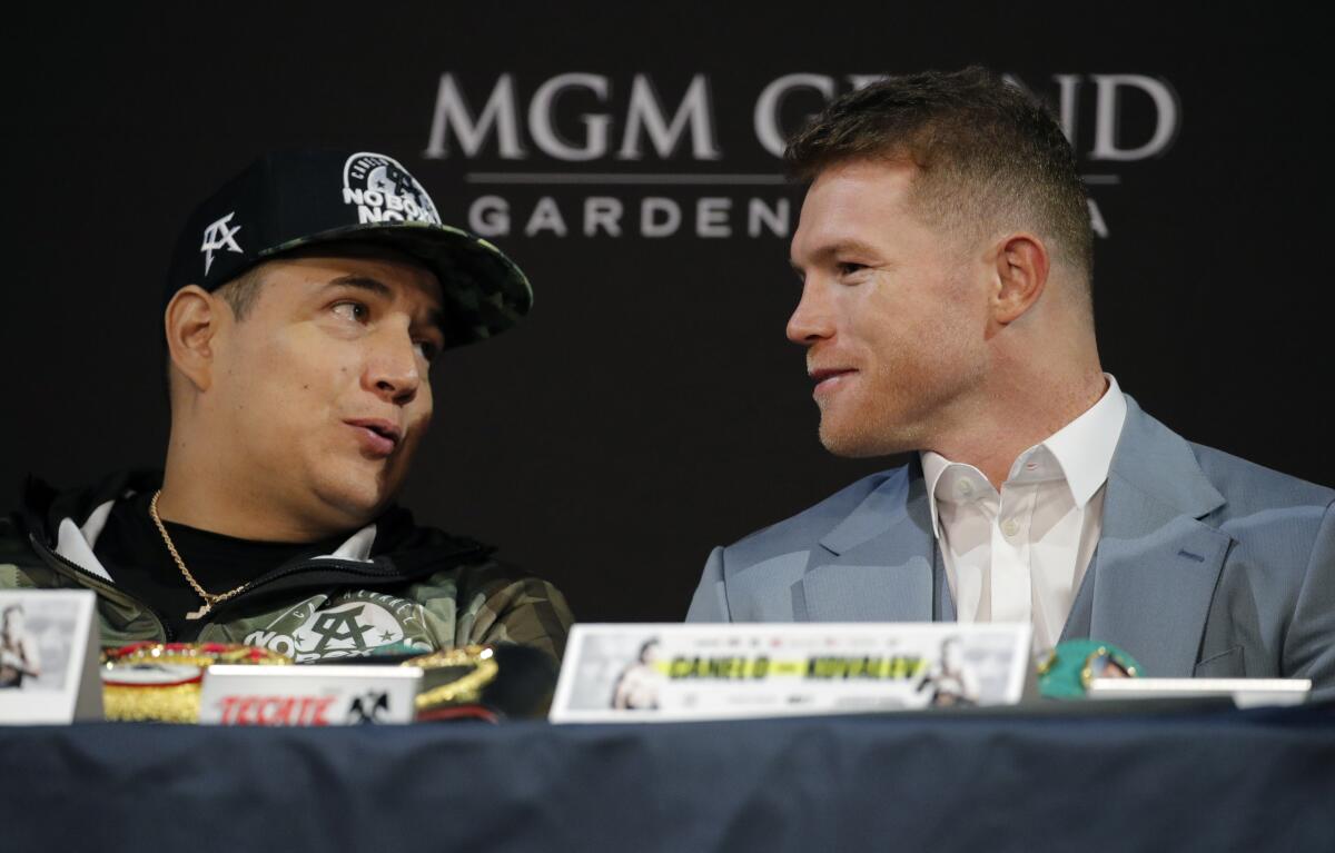Canelo ?lvarez speaks with trainer Eddy Reynoso during a news conference 