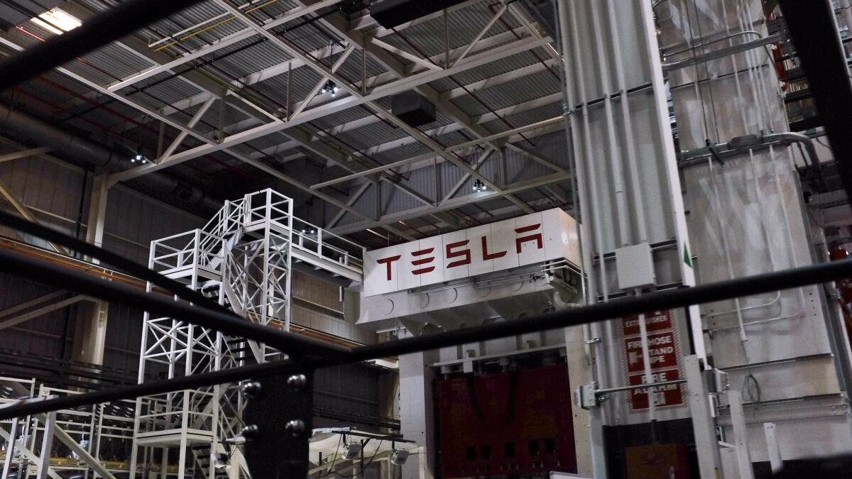 Tesla CEO Elon Musk said Monday that Tesla would restart production at its plant in Fremont, Calif., and flout county officials who ordered the company to keep the factory closed. Above, inside the assembly plant.