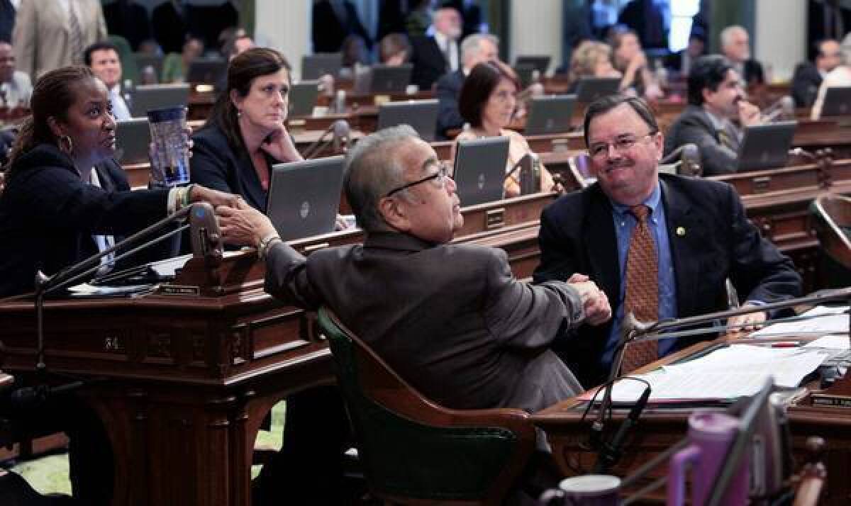 Assemblyman Warren Furutani (D-Gardena), center, receives congratulations from colleagues Holly Mitchell (D- Los Angeles) and Richard Gordon (D-Menlo Park) after his pension reform bill was approved by the Assembly on Friday.