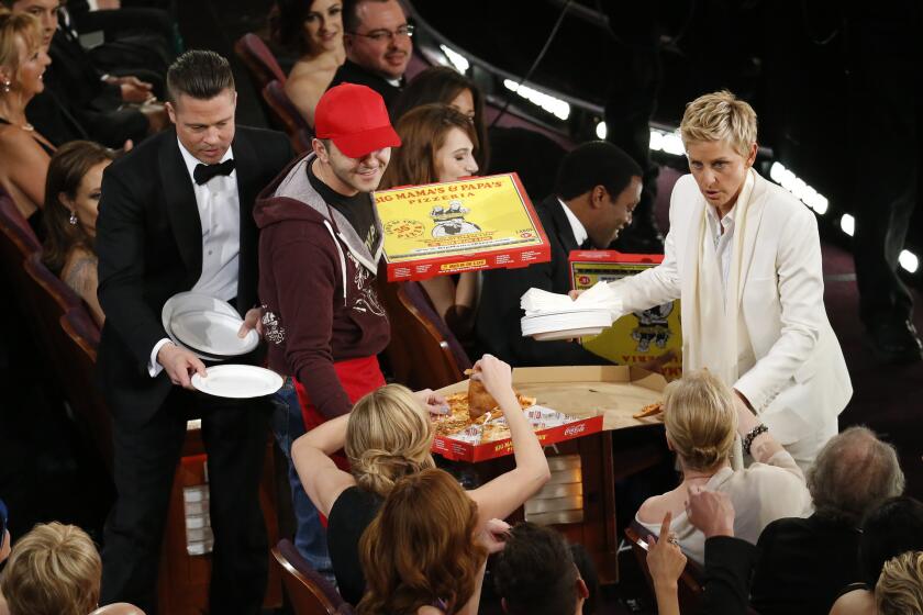 Ellen DeGeneres distributes pizza and Brad Pitt hands out paper plates in one of the host's informal bits. She seemed to forget how unwieldy the show is.