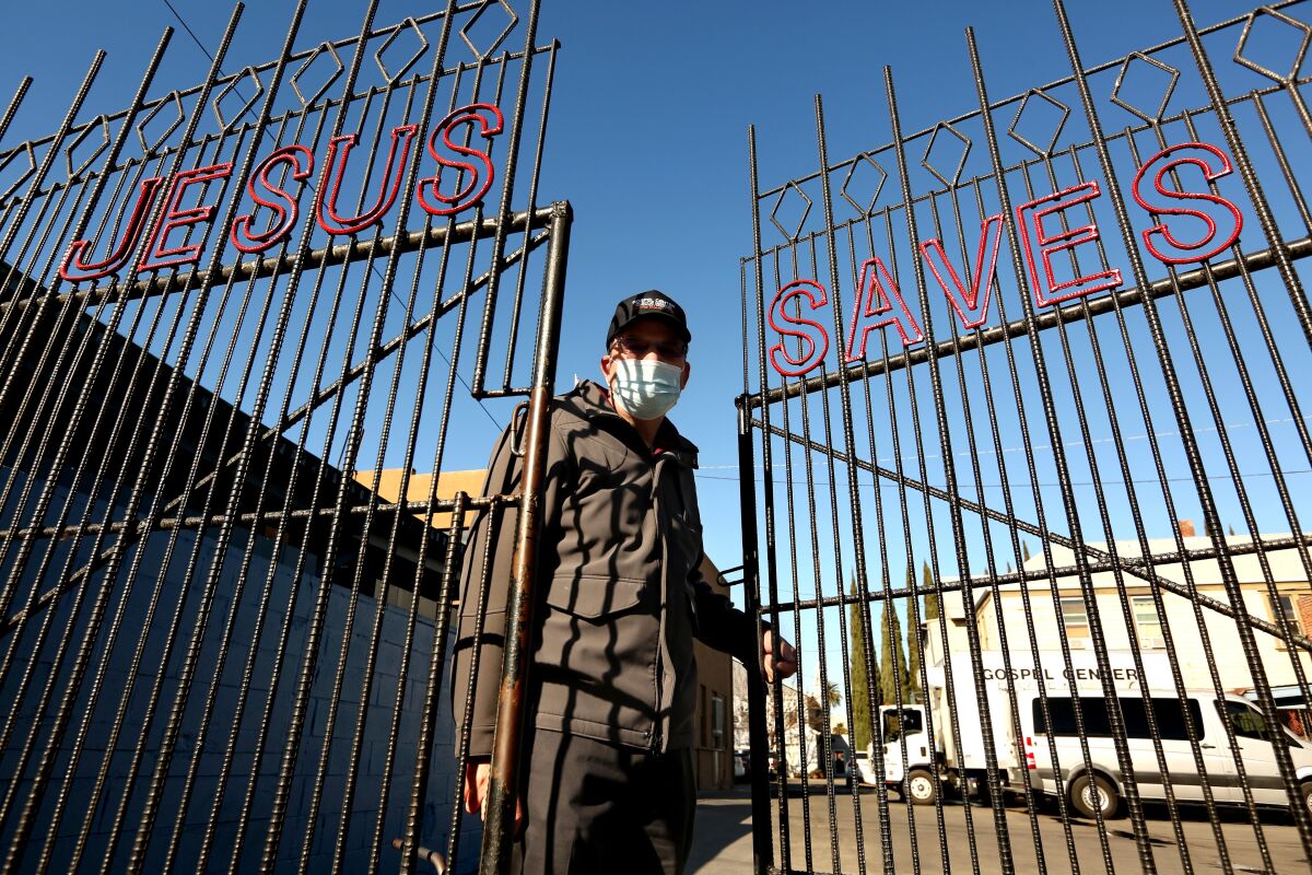 A man opening a gate that says "Jesus Saves"