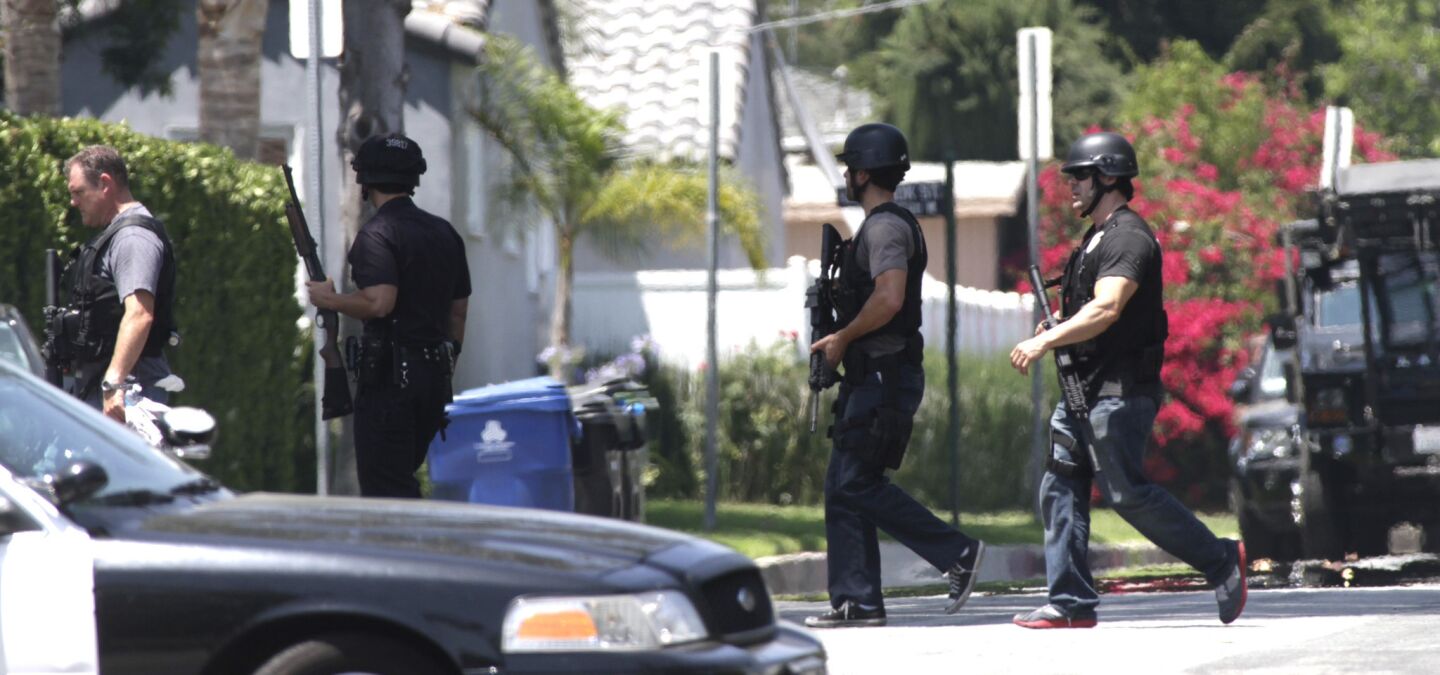 Officers search a North Hollywood neighborhood for a man with a rifle who was hiding in the area.