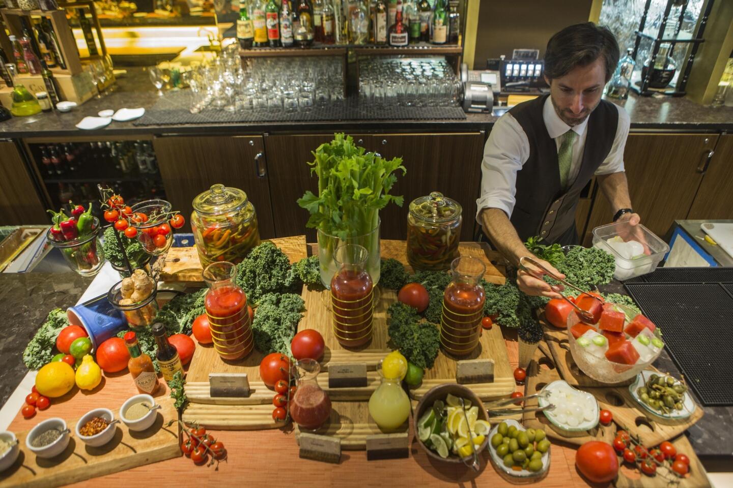 Bartender Ryan Burney places ice cubes at the Four Seasons hotel's Sunday brunch Bloody Mary bar.