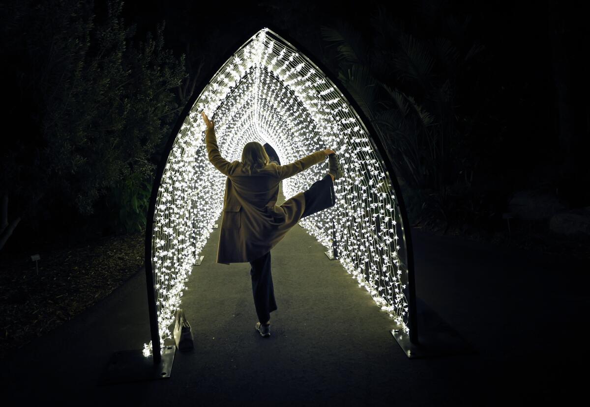 Christine Tara Peterson does a yoga pose in the Winter Cathedral at Lightscape at the San Diego Botanic Garden.