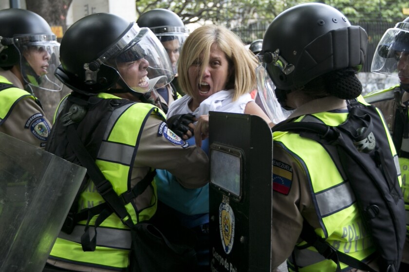 An anti-government demonstrator clashes with police during protests against the government of President Nicolas Maduro.