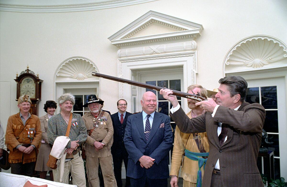 President Reagan aims a gun as others look on in the documentary "The Price of Freedom."