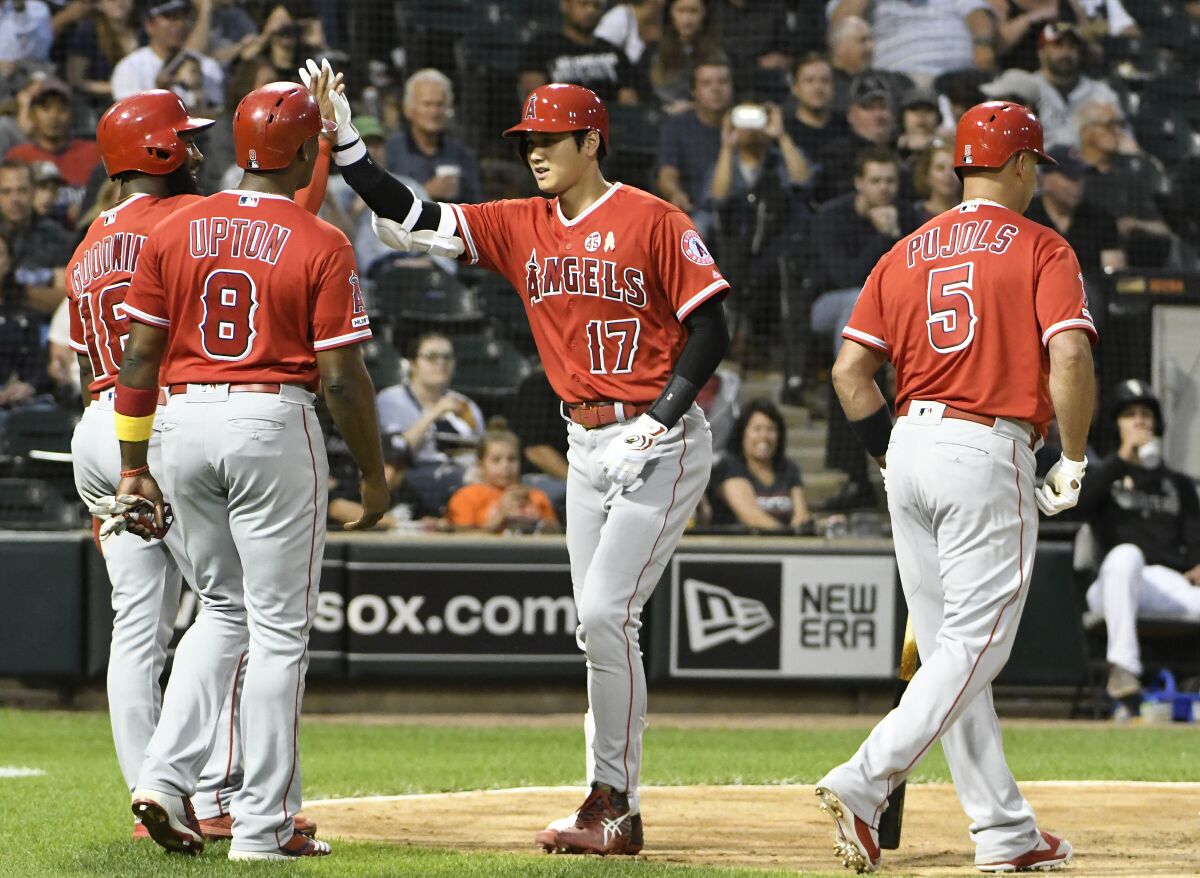 The Angels' Shohei Ohtani is greeted by teammates after hitting a three-run homer Sept. 7, 2019.