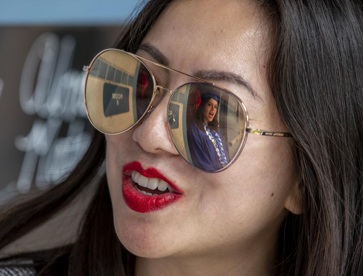 A Valley Vista graduate is reflected in the glasses of Angel Dam.