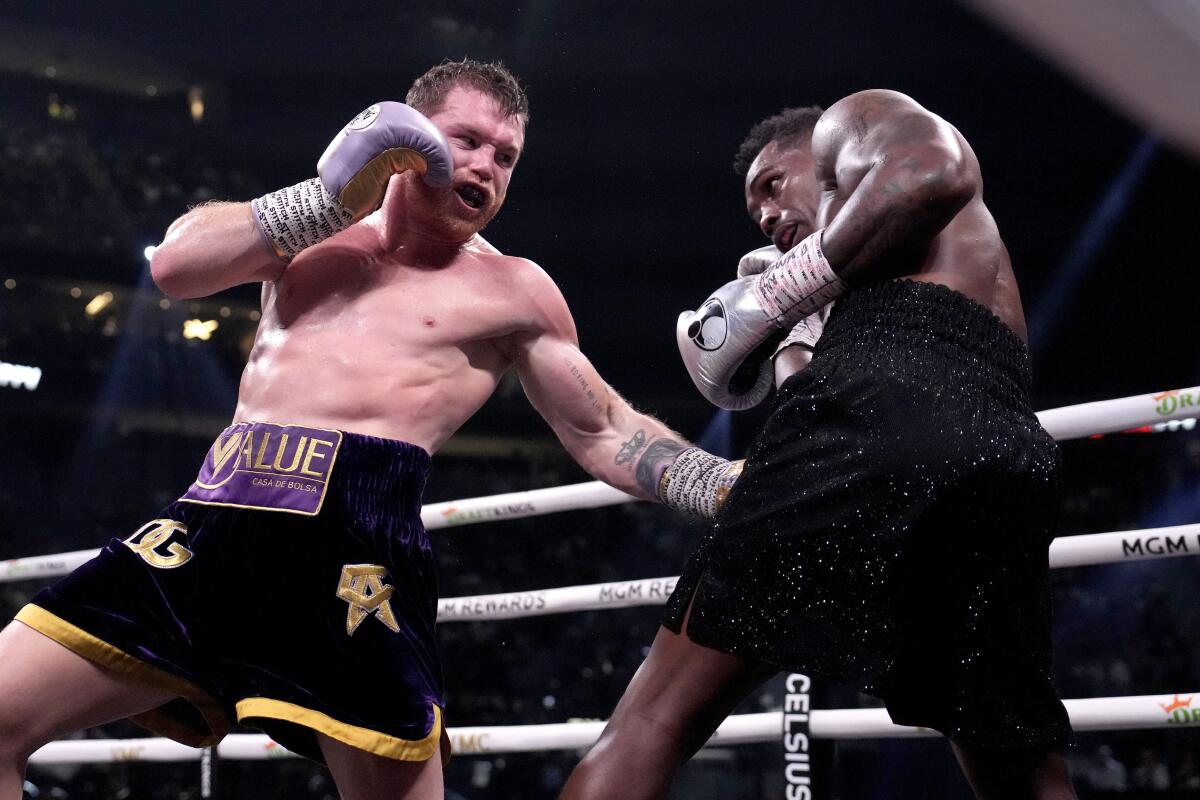 Canelo Álvarez lands a left hook to Jermell Charlo in the ring.