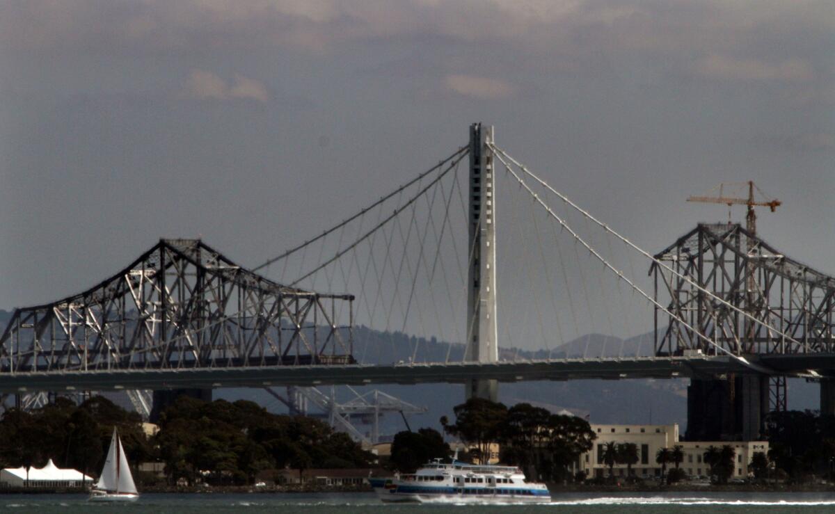 A tour boat passes the new Oakland Bay bridge as the old one is dismantled in San Francisco Bay.