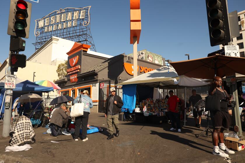 Los Angeles, CA - October 25: Vendors sell items and people walk by next to the Yoshinoya at MacArthur Park on Friday, Oct. 25, 2024 in Los Angeles, CA. (Michael Blackshire / Los Angeles Times)