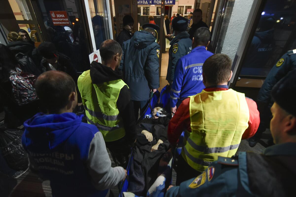 Volunteers and paramedics carrying an elderly evacuee from Kherson, Ukraine.