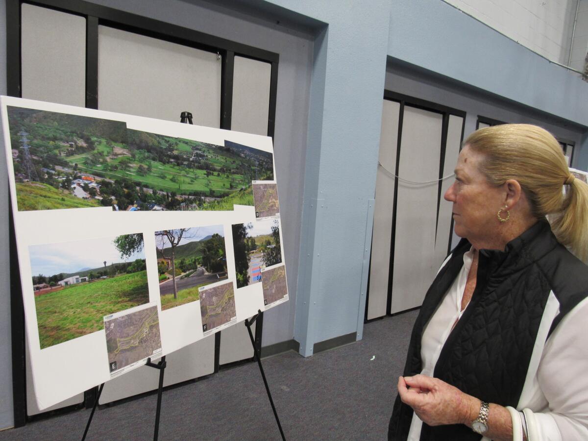 Deborah Hafer of El Cajon looks over proposed plans for Cottonwood Golf Club at a meeting on Nov. 4 at Hillsdale Middle School in Rancho San Diego. Hafer, a regular golfer on the course, is part of a contingent concerned about the owner's plans to turn the Cottonwood grounds into a sand mining operation.