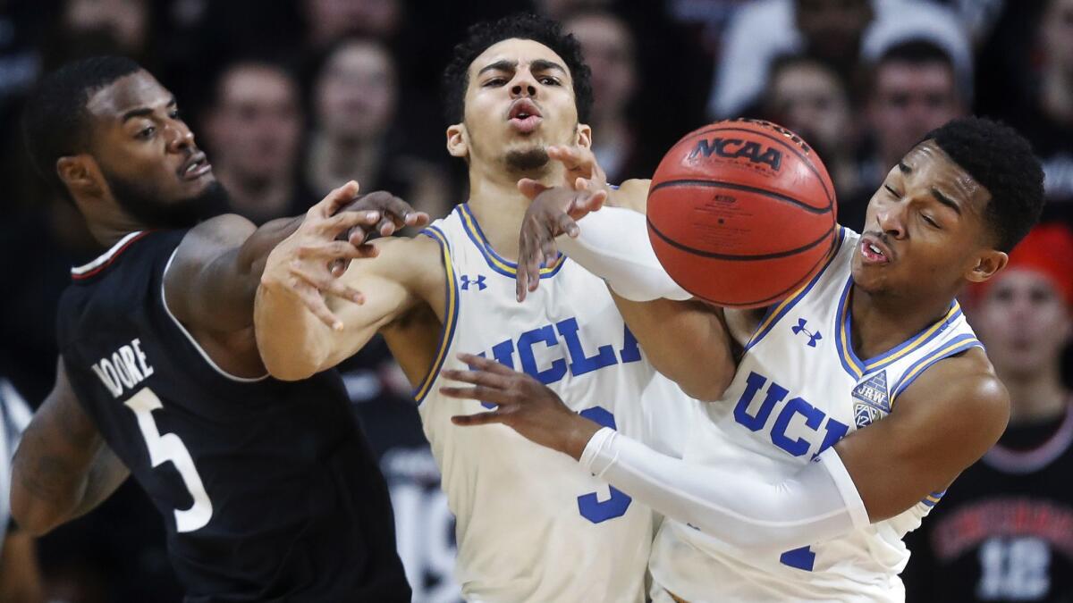 Cincinnati's Trevor Moore (5), UCLA's Jules Bernard (3) and Cody Riley (2) battle for a rebound during the second half on Dec. 19, 2018, in Cincinnati.