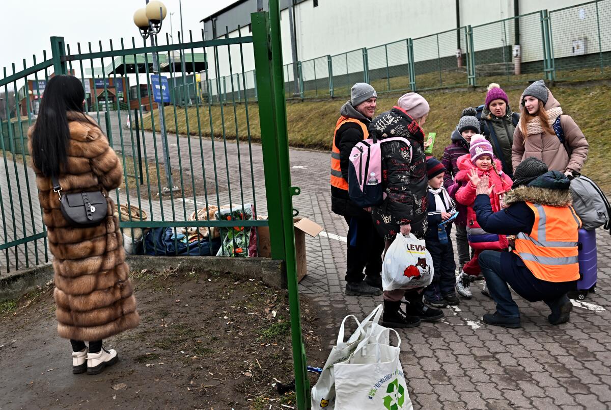 Volunteer James Hobbs high-fives Ukrainian refugees as they cross the border.