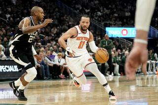 Jalen Brunson (11), de los Knicks de Nueva York, lleva el balón a la canasta, ante Khris Middleton, izquierda, de los Bucks de Milwaukee, durante la primera mitad del juego de baloncesto de la NBA, el domingo 7 de abril de 2024, en Milwaukee. (AP Foto/Aaron Gash)