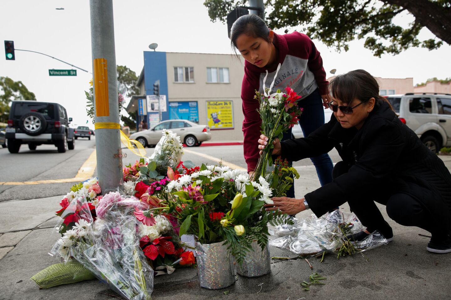 Amy Miyamoto and daughter Katie, 13, place flowers at the corner of Vincent Street and Pacific Coast Highway in Redondo Beach the morning after an accident killed three pedestrians and injured others.