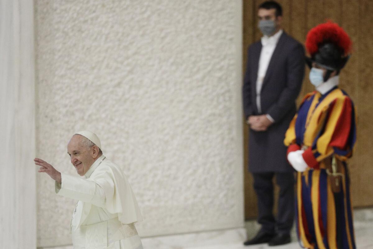 Pope Francis waves at the end of his weekly general audience in the Paul VI hall at the Vatican.