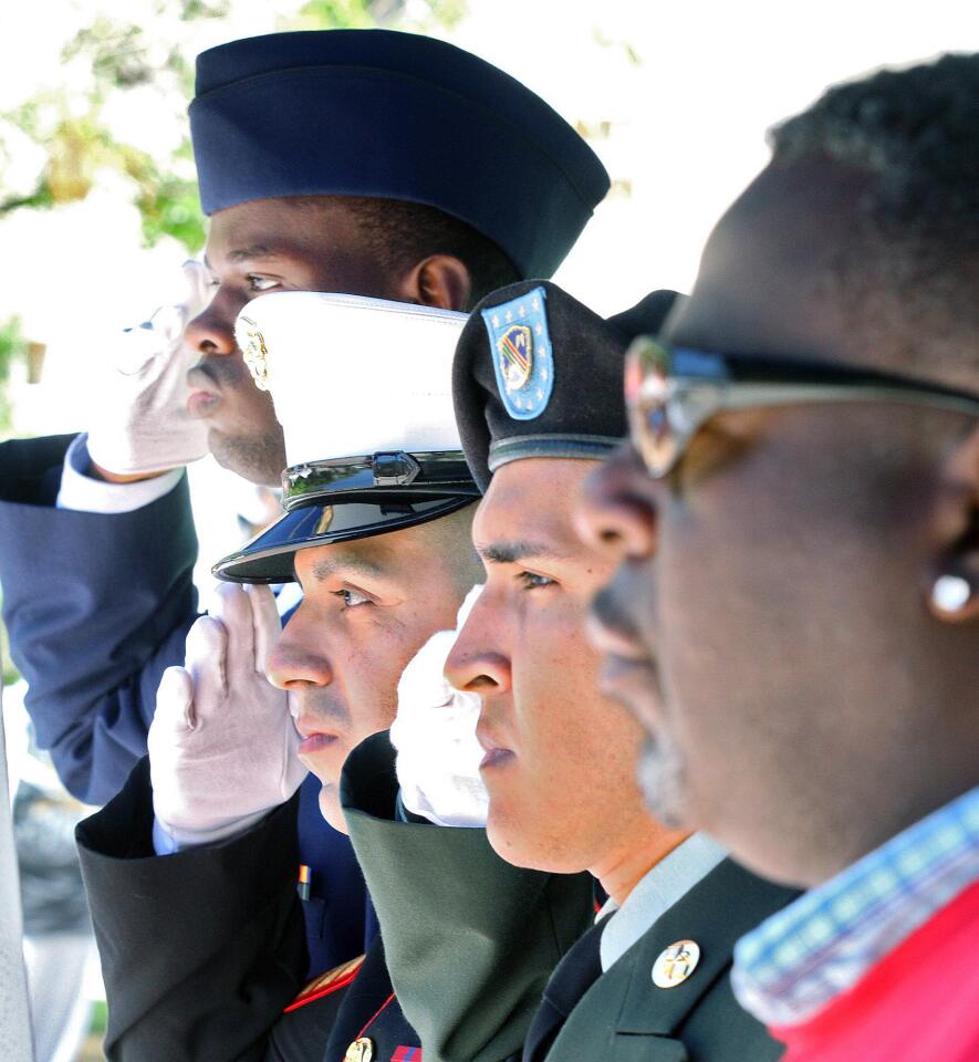 Jason Noralez, Navy/Air Force, Jerson Contreras, USMC, Jorge Tello, Army Reserve, and Charles Shumate, salute the American Flag during the plaing of Taps during the GCC Veterans Association Memorial Day commemoration at Vaquero Plaza at Glendale Community College on Tuesday, May 20, 2014.